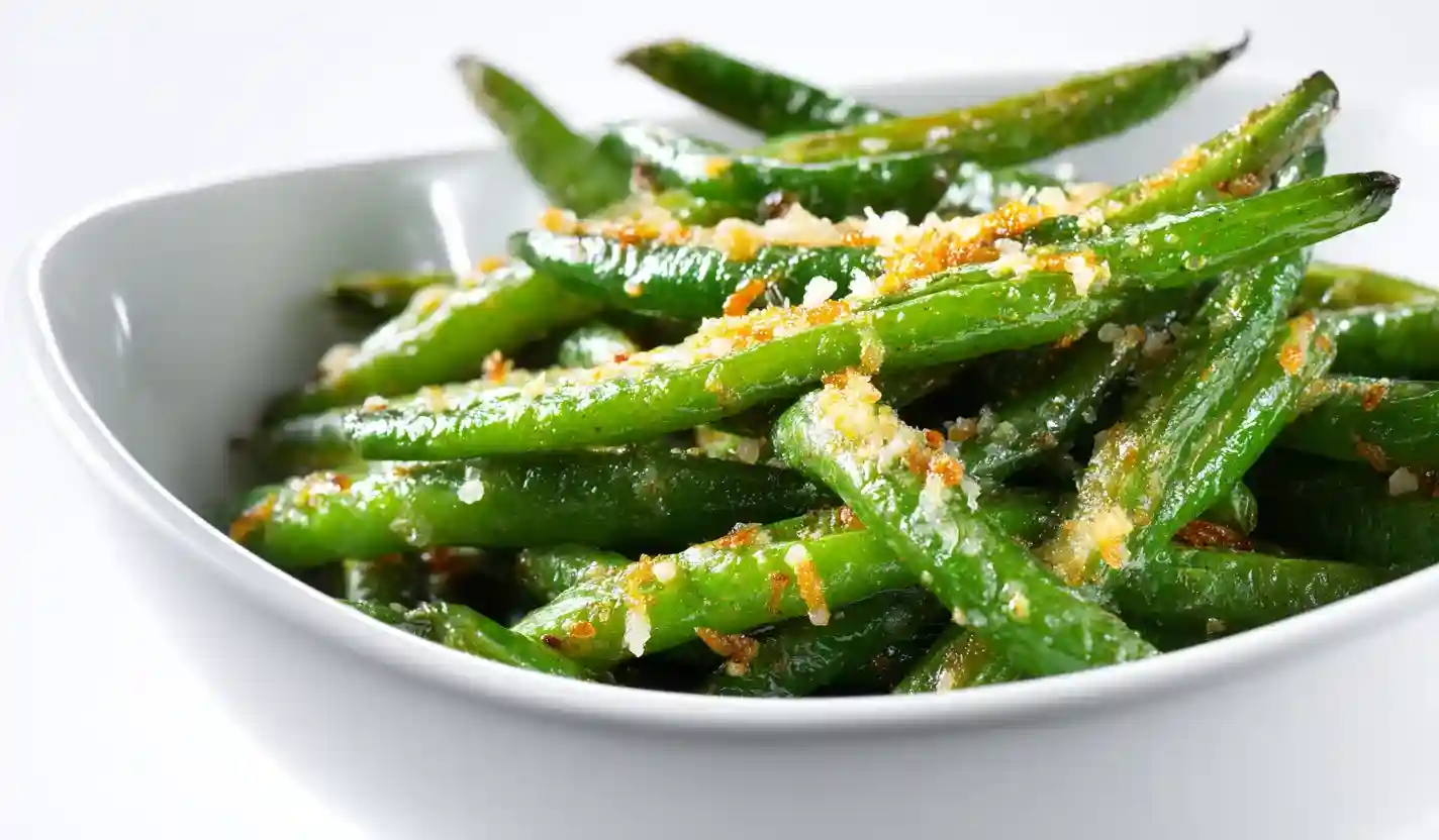 Oven roasted green beans with garlic and Parmesan in a modern white bowl, 45-degree close-up.